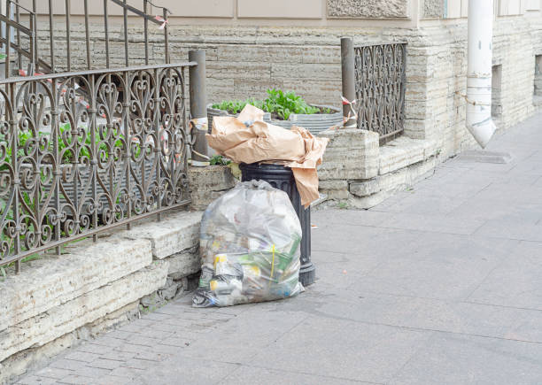 istock overflowing garbage litter bin and full plastic package with garbage in the street. 1405008598