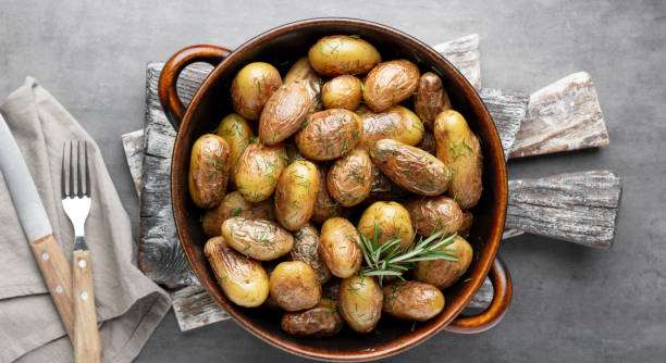 istock Pan filled with roasted potatoes shot on rustic wooden table. 1405012284