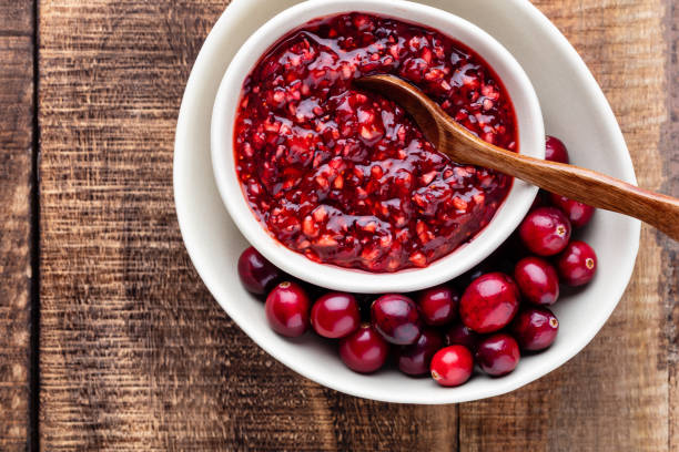 istock Red cranberries on wooden background. Brries in a bowl. 1405013171