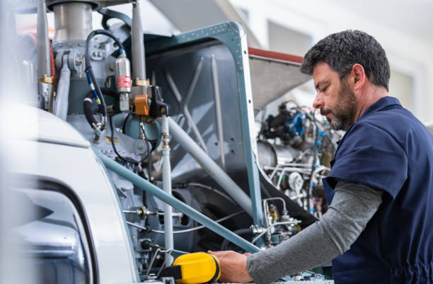 istock Male Aero Engineer With Clipboard Checking On Helicopter In Hangar 1405013322