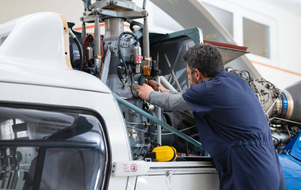 istock Aero Mechanic Fixing And Checking A Helicopter In Hangar 1405013336