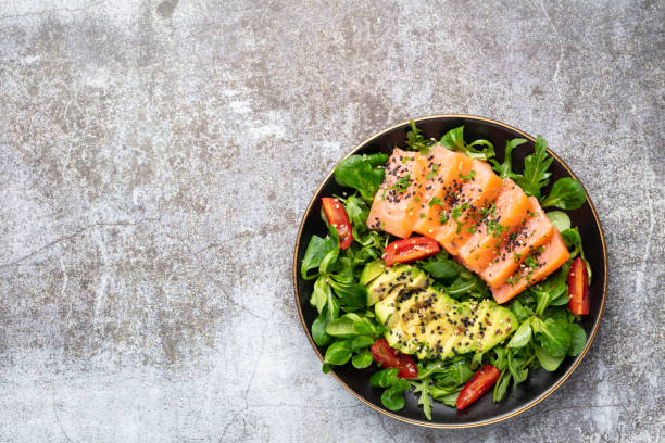 istock Salmon fish fillet with fresh salad, avocado top view. 1405013664