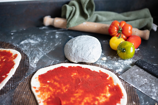 Making homemade pizza with fresh tomatoes and dough