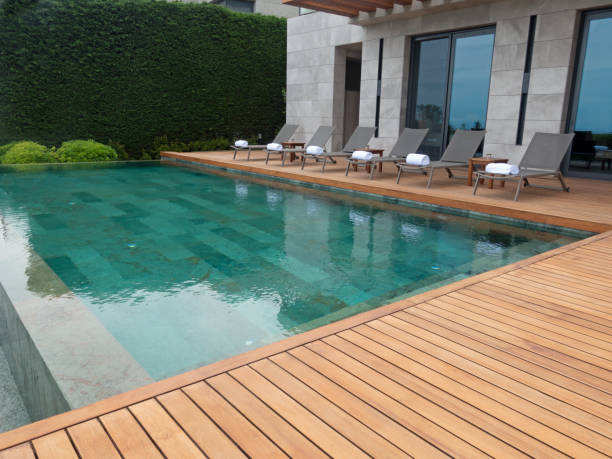 istock Deck chairs on Wooden plank floor against swimming pool 1405019871
