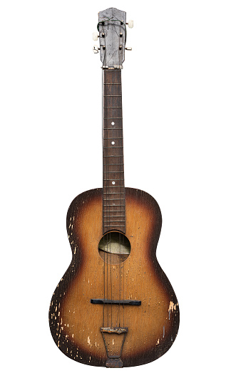 front view closeup of old brown grungy acoustic guitar with broken chords isolated, on white background