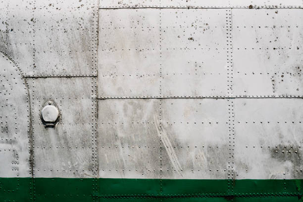 metal airplane hull plating with rows of rivets front view closeup of old airplane metallic hull fuselage plating with rows of bolts and rivets industrial texture rivet work tool stock pictures, royalty-free photos & images