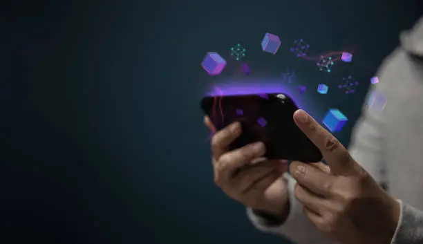 Metaverse, Web3 and Blockchain Technology Concepts. Closeup of Hand Using Smartphone for Connect a Community or Playing NFT Virtual Game