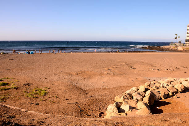 Man walking in the Atlantic Ocean at Playa de las Americas which is a popular tourist location on the south coast of the the Spanish Canary Island Tenerife.