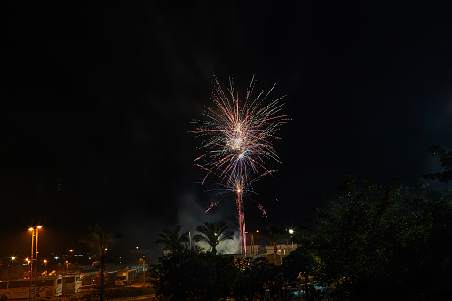 Multicolored fireworks in the night sky. Celebration of Independence Day, New Year and other holidays.