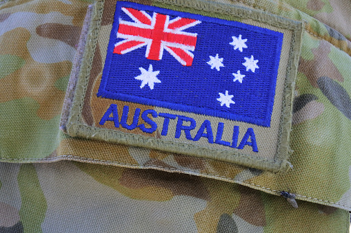 Bandera del ejército australiano en uniforme de camuflaje militar photo
