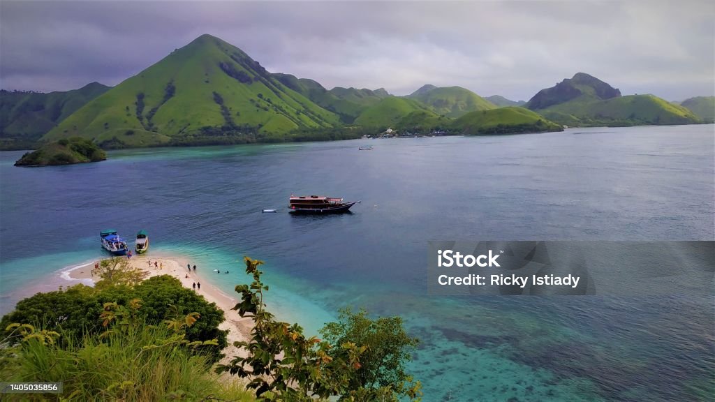 Wooden Boat Wooden Boat With Green Hill in Labuan Bajo Komodo National Park Stock Photo