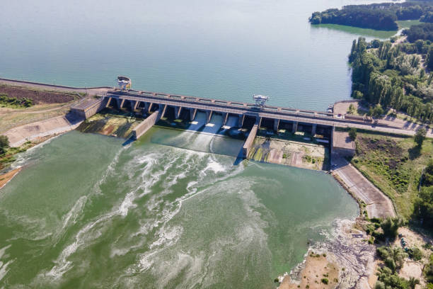 istock Hydroelectric dam with flowing green water through gate 1405035925
