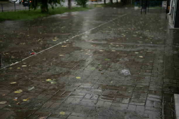 istock heavy rain drops falling on city street 1405037178