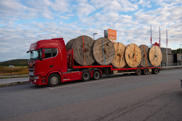 Red lorry fully loaded with large empty cable drums.. Strömstad, Sweden - October 13 2021: Red lorry fully loaded with large empty cable drums. wooden spool stock pictures, royalty-free photos & images