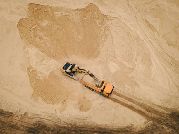 istock Excavator loading sand into a dump truck in opencast sand quarry 1405039591