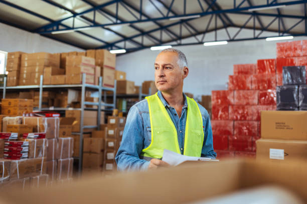 istock Male storage room operator holding clipboard while going through checklist indoors 1405039857