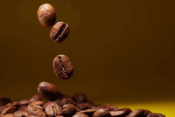 istock Roasted coffee beans isolated close up on yellow background, clipping path 1405039942