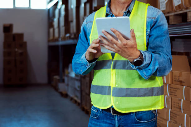istock Photo of employee using digital tablet by shelf. 1405040804