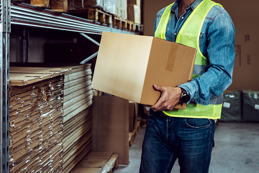 Male worker holding box, shipping delivery process, business distribution