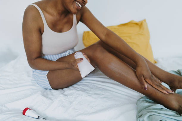 istock Young woman applying moisturizer on her skin 1405042237
