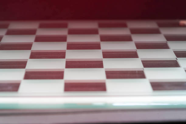Chess with game pieces made of glass, queen, king, pawn and game board made of glass in black and white