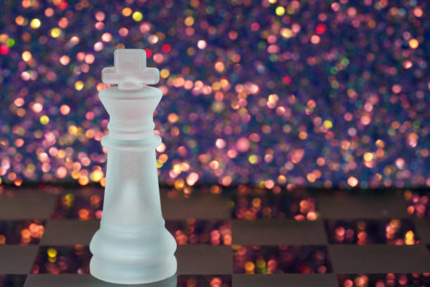Chess with game pieces made of glass, queen, king, pawn and game board made of glass in black and white