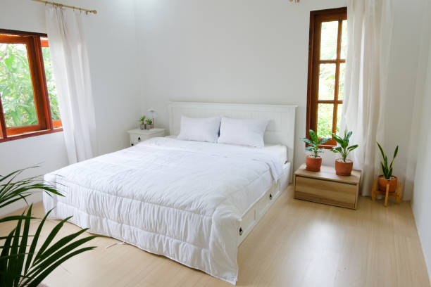 istock Minimal bedroom with wooden floor, white bed and plants 1405051602