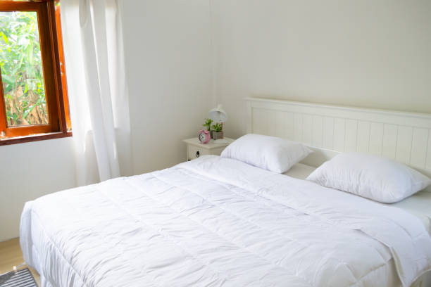 istock Minimal bedroom with wooden floor, white bed and plants 1405051808