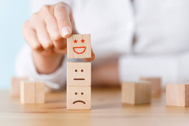 istock Customer hand choose smiley face on wood cube, Service rating, satisfaction concept 1405052755