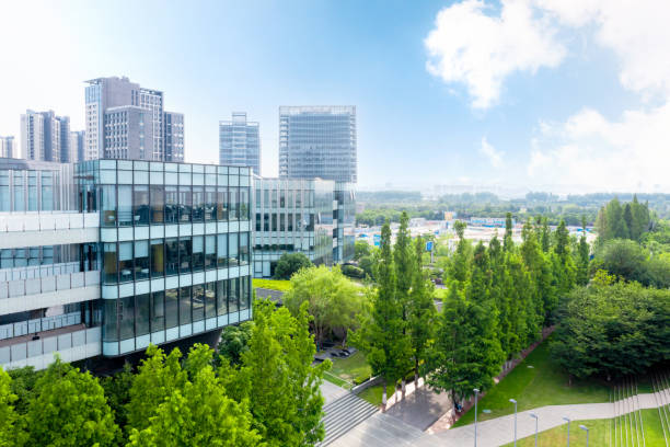 trees by road against buildings in city aerial view of modern eco city office building stock pictures, royalty-free photos & images