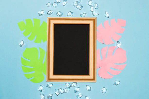 istock old wooden frame with black copy space around it blue wallpaper with gemstone and jungle colorful paper leaves, creative summer elegant design 1405056435