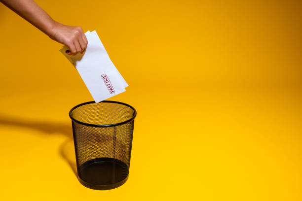istock The hand throws into the trash envelopes with a bank red mark overdue. Postal envelopes are thrown into the wastebasket. Paper mail creates waste and pollutes the environment. 1405059143