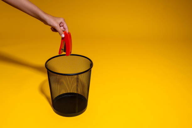 istock A hand throws a red stapler into the trash. A large drawing stapler is thrown into the office wastebasket. The concept of getting rid of office supplies for paperwork 1405059787