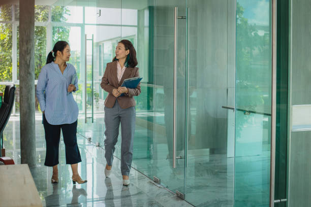 istock Asian business people colleagues working together discussing while walking at modern office corridor 1405060216