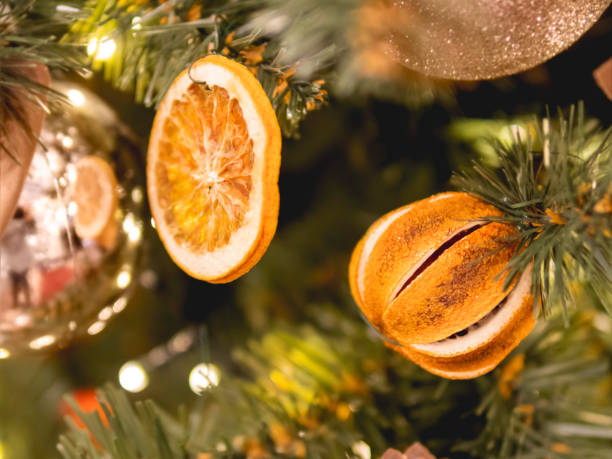 Christmas tree with dried lemons and natural decorations. Fir tree decorated with light bulbs and shiny balls for New Year celebration. stock photo