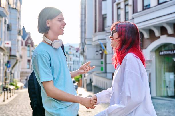 treffen, hände schütteln jugendliche männliche und weibliche freunde auf der stadtstraße - greeting teenager handshake men stock-fotos und bilder