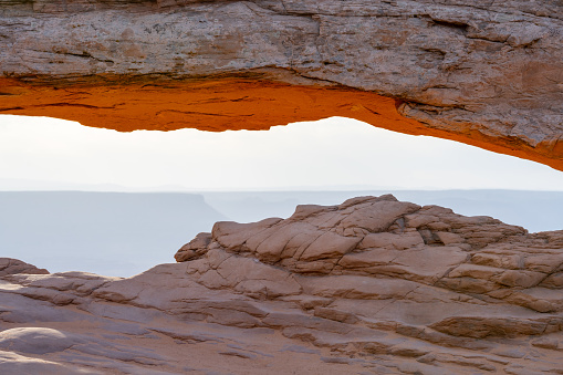 The sunrise at the Mesa Arch in the Canyonlands National Park makes the arch glow. Seen in Utah, USA.