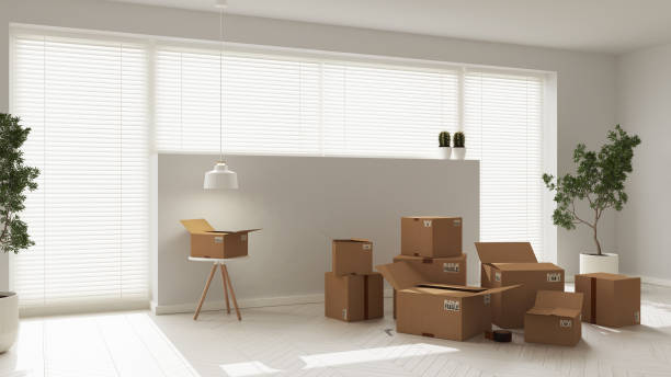 istock Cardboard carton boxes stack in modern empty room, interior design. Window with venetian blinds and white parquet floor, potted plants. Moving concept idea 1405066867