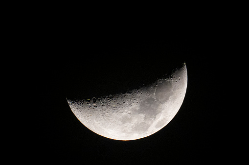 Close-up of a half moon seen on black space background at night.