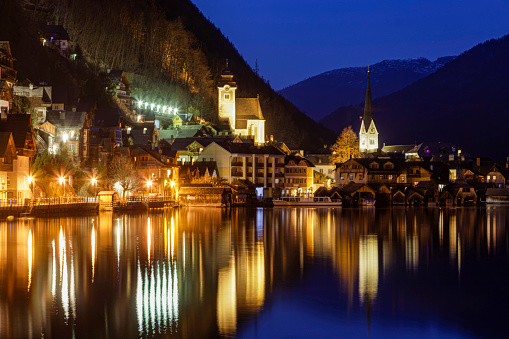 Hallstatt in the Salzkammergut Upper Austria is a world-famous tourist destination and is located on Lake Hallstatt. Night shot with illuminated Catholic and Protestant churches.