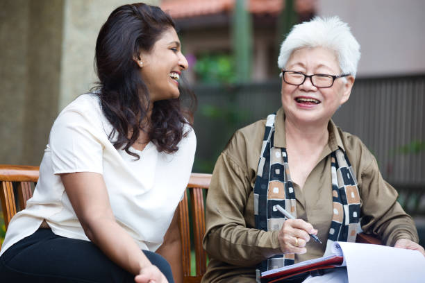 istock Financial advisor assisting old asian woman filling forms 1405075534