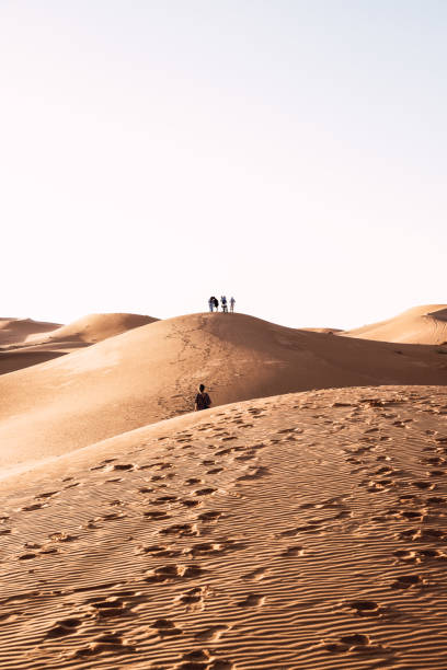istock People walking in the dunes 1405075594