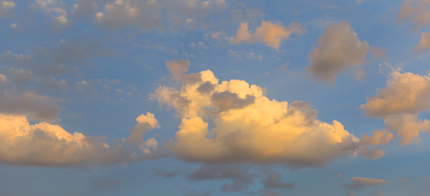 cumulus clouds on evening blue sky background