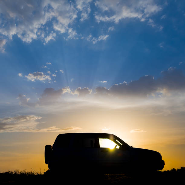 istock car silhouette on dramatic cloudy sky background at the sunset 1405077640