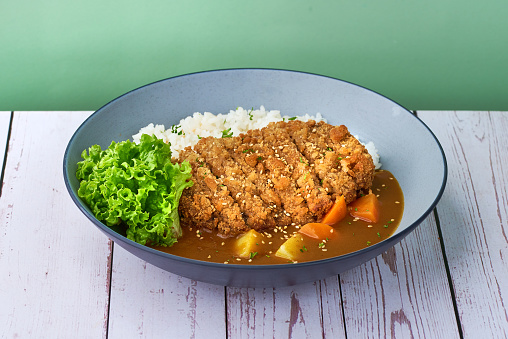 Traditional japanese food rice and katsu curry in a bowl on wooden table background