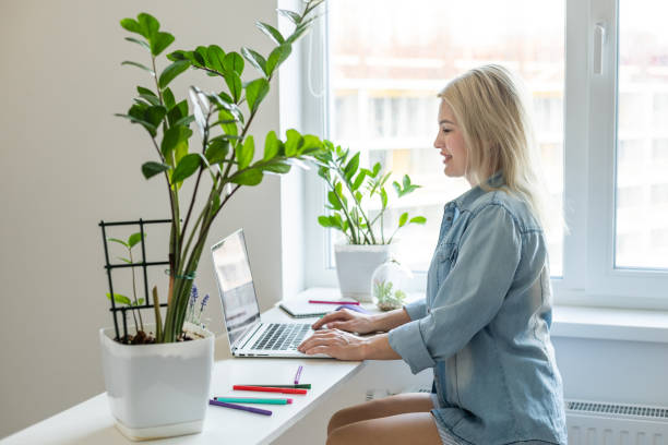istock Woman on remote work or online education, using laptop computer, making notes, indoors at office or home at daytime. Online business, young professional at workplace. Working from home. 1405079238