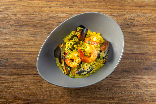Mussel Prawn Soupy Rice served in a dish top view on dark wooden background