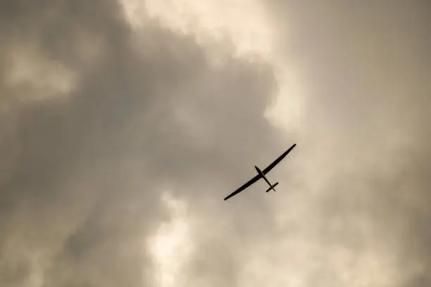 Sky sights, dramatic sky,  sailplane flying among rain clouds in gray sky