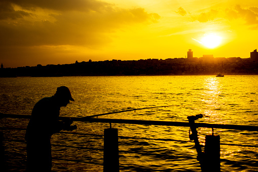 Senior man fishing at sunset