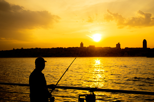 Senior man fishing at sunset